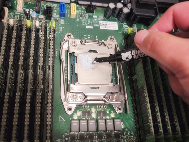 Applying thermal paste to a processor during a homelab hardware project.